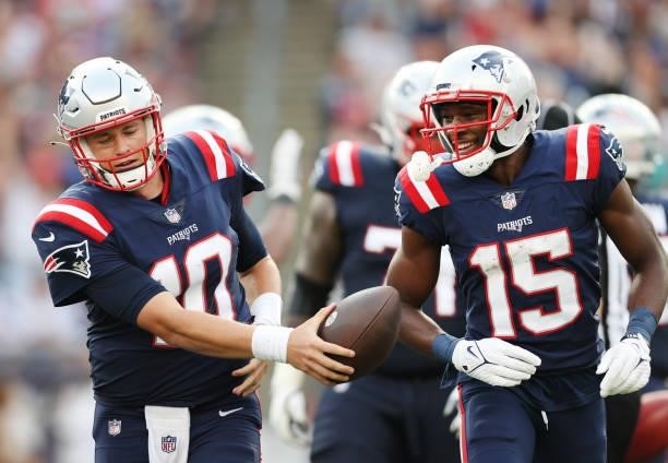 Mac Jones and Nelson Agholor of the New England Patriots celebrate after a seven yard touchdown pass against the Miami Dolphins during the second...