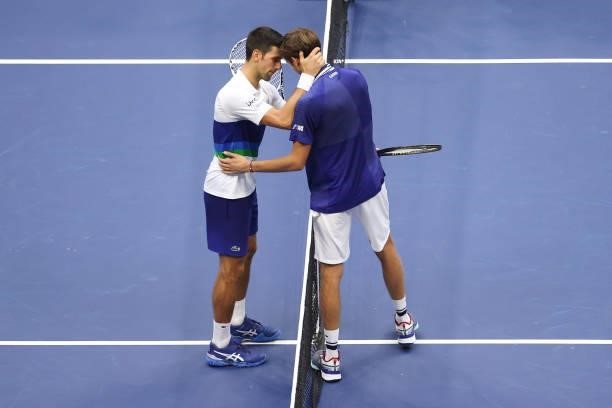 Daniil Medvedev of Russia and Novak Djokovic of Serbia talk at center court after Medvedev won their Men's Singles final match on Day Fourteen of the...