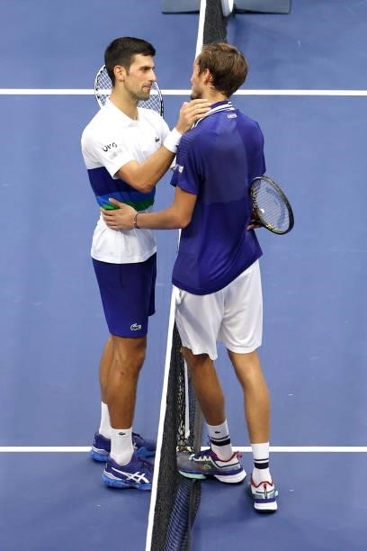 Daniil Medvedev of Russia and Novak Djokovic of Serbia talk at center court after Medvedev won their Men's Singles final match on Day Fourteen of the...