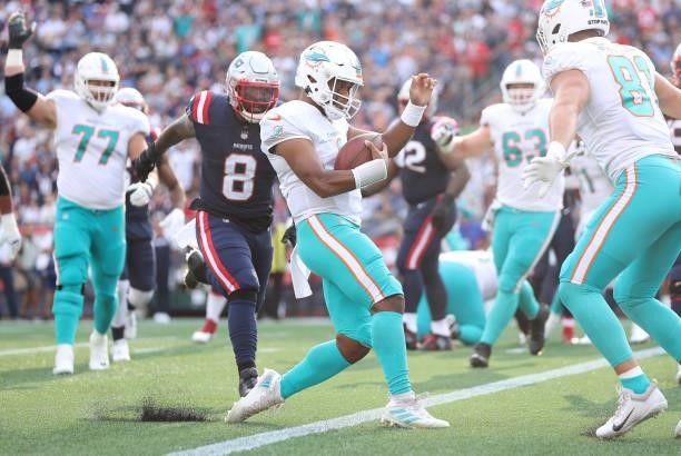 Tua Tagovailoa of the Miami Dolphins scores a three yard rushing touchdown against the New England Patriots during the first quarter at Gillette...