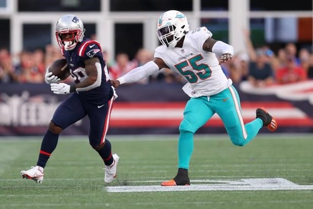 James White of the New England Patriots makes a catch past the reach of Jerome Baker of the Miami Dolphins during the second half at Gillette Stadium...