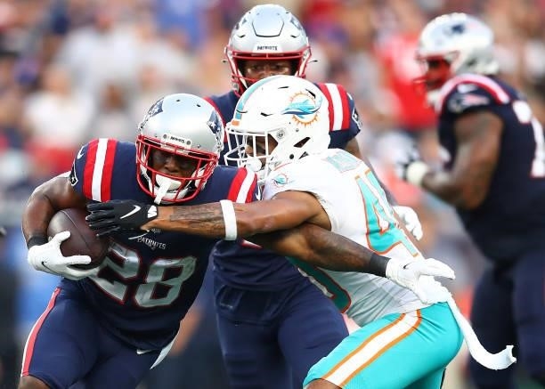 James White of the New England Patriots runs with the ball against Nik Needham of the Miami Dolphins during the second half at Gillette Stadium on...