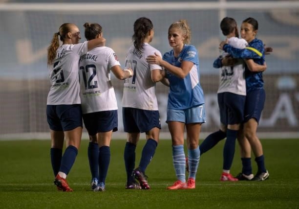 Maéva Clemaron of Tottenham Hotspur shakes hands with Laura Coombs of Manchester City whilst team mates Ria Percival and Molly Bartrip embrace after...