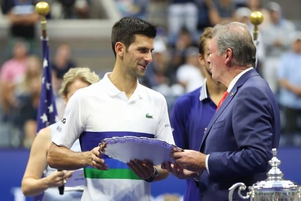 Novak Djokovic of Serbia is awarded the runner-up trophy by USTA President Michael McNulty after being defeated by Daniil Medvedev of Russia during...