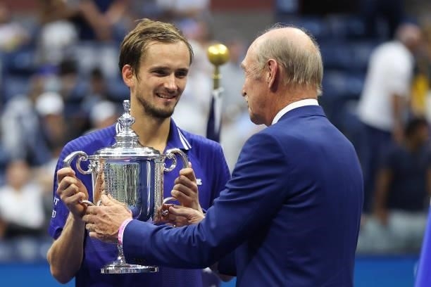 Daniil Medvedev of Russia is awarded the championship trophy by former tennis player Stan Smith after defeating Novak Djokovic of Serbia to win the...
