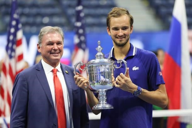 Daniil Medvedev of Russia holds with the championship trophy alongside USTA President, Michael McNulty, after defeating Novak Djokovic of Serbia to...