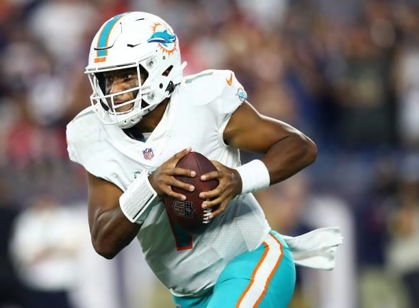 Tua Tagovailoa of the Miami Dolphins carries the ball during the second half against the New England Patriots at Gillette Stadium on September 12,...