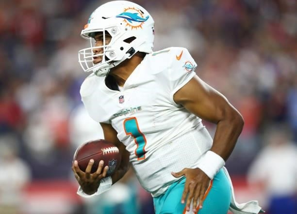 Tua Tagovailoa of the Miami Dolphins carries the ball during the second half against the New England Patriots at Gillette Stadium on September 12,...
