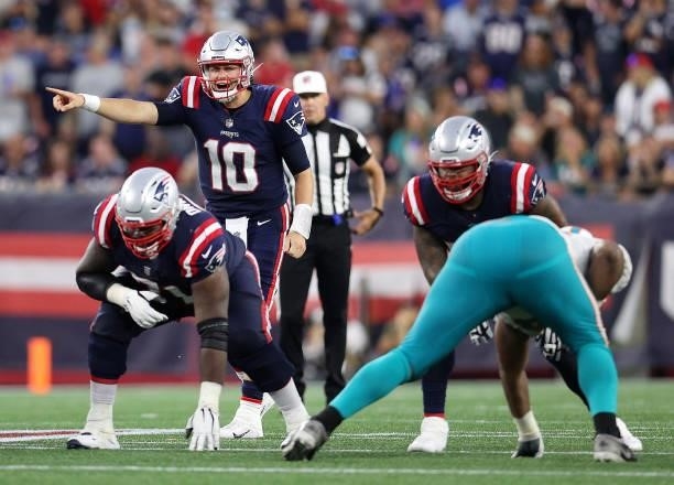 Mac Jones of the New England Patriots directs the offense against the Miami Dolphins at Gillette Stadium on September 12, 2021 in Foxborough,...