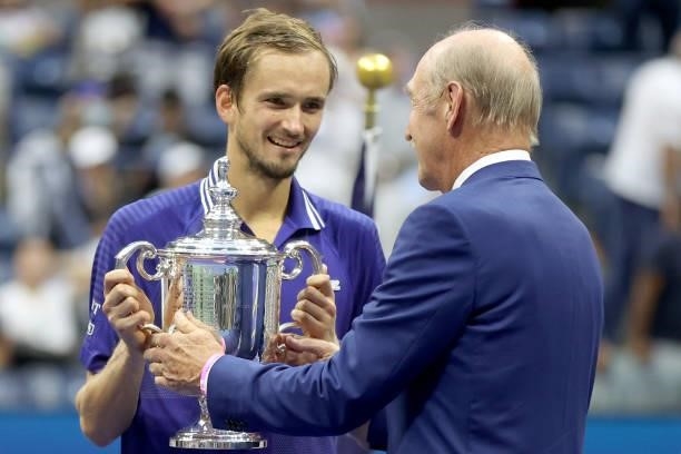 Daniil Medvedev of Russia is awarded the championship trophy by former tenner player, Stan Smith, after defeating Novak Djokovic of Serbia to win the...