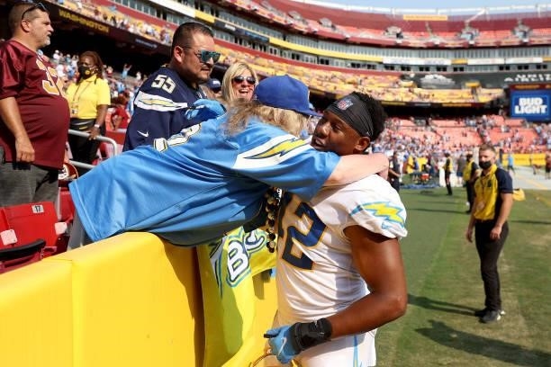 Linebacker Uchenna Nwosu of the Los Angeles Chargers hugs a fan after the Chargers defeated the Washington Football Team at FedExField on September...