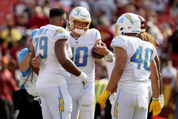 Quarterback Justin Herbert of the Los Angeles Chargers celebrates with offensive tackle Trey Pipkins and running back Gabe Nabers after the Chargers...