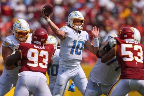 Justin Herbert of the Los Angeles Chargers makes a pass against the Washington Football Team at FedExField on September 12, 2021 in Landover,...