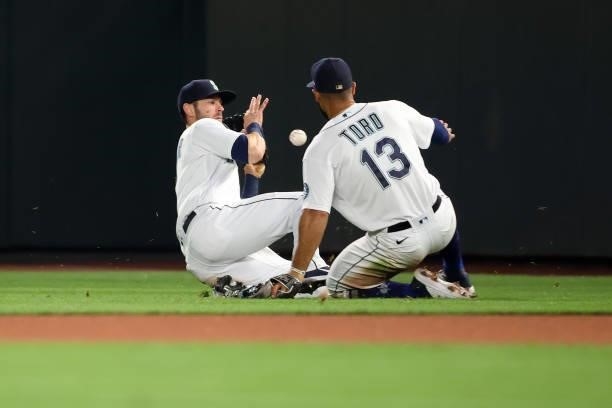 Mitch Haniger and Abraham Toro of the Seattle Mariners collide as they are unable to make the play off an RBI single by Jose Iglesias of the Boston...