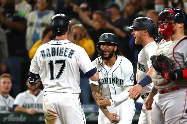 Mitch Haniger of the Seattle Mariners celebrates while crossing home plate after hitting a three-run home run against the Boston Red Sox in the...