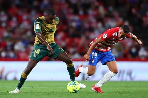 Angel Montoro of Granada CF competes for the ball with Willian Carvalho of Real Betis during the LaLiga Santander match between Granada CF and Real...