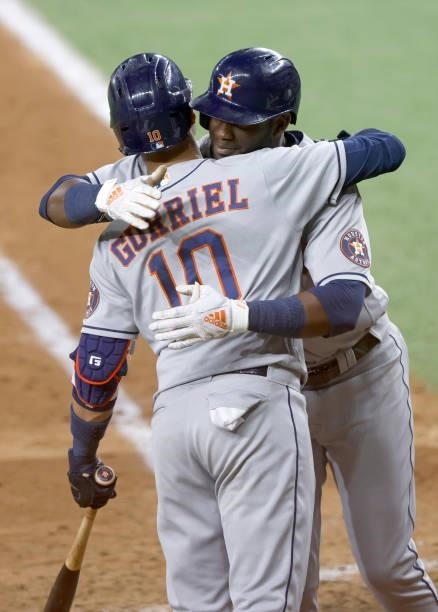 Yordan Alvarez of the Houston Astros hugs teammate Yuli Gurriel after hitting a two-run home run against the Texas Rangers during the seventh inning...