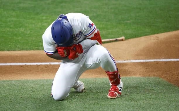Adolis Garcia of the Texas Rangers reacts after being hit by a pitch against the Houston Astros during the third inning at Globe Life Field on...