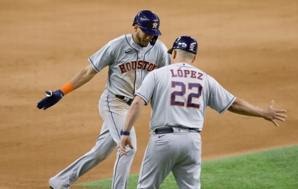 Jose Siri of the Houston Astros celebrates with third base coach Omar Lopez after hitting a solo home run against the Texas Rangers during the eighth...