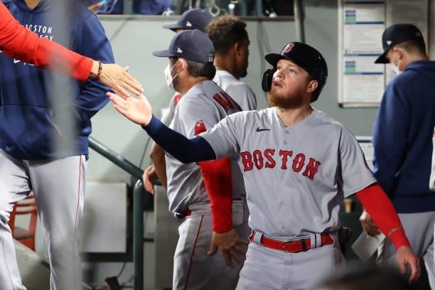 Alex Verdugo of the Boston Red Sox celebrates in the dugout after scoring off a RBI single by Jose Iglesias to tie the game 2-2 against the Seattle...