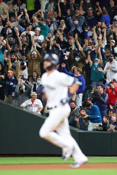 Fans cheer as Mitch Haniger of the Seattle Mariners laps the bases after hitting a three-run home run against the Boston Red Sox to take a 5-2 lead...