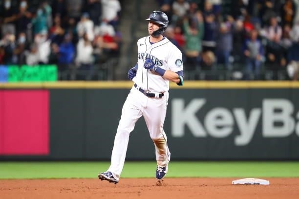 Mitch Haniger of the Seattle Mariners laps the bases after hitting a three-run home run against the Boston Red Sox to take a 5-2 lead in the seventh...