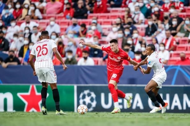 Benjamin Sesko of FC Salzburg challenged by Fernando and Jules Kounde of FC Sevilla during the UEFA Champions League group G match between Sevilla FC...