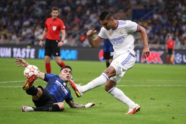 Lautaro Martinez of FC Internazionale slides in to challenge Casemiro of Real Madrid during the UEFA Champions League group D match between Inter and...