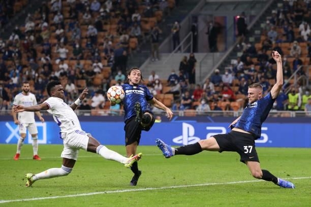 Matteo Darmian and Milan Skriniar of FC Internazionale stretch to clear the ball from Vinicius Junior of Real Madrid during the UEFA Champions League...