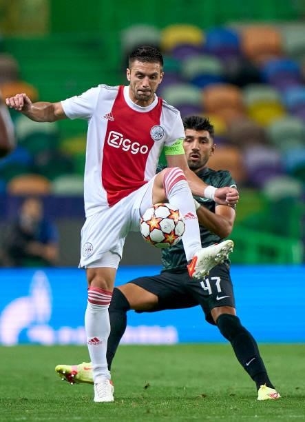 Dusan Tadic of Ajax is challenged by Ricardo Esgaio of Sporting CP during the UEFA Champions League group C match between Sporting CP and AFC Ajax at...