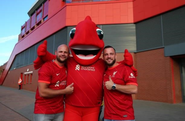 Supporters of Liverpool pose for photographs with Mighty Red the Liverpool mascot prior to the UEFA Champions League group B match between Liverpool...