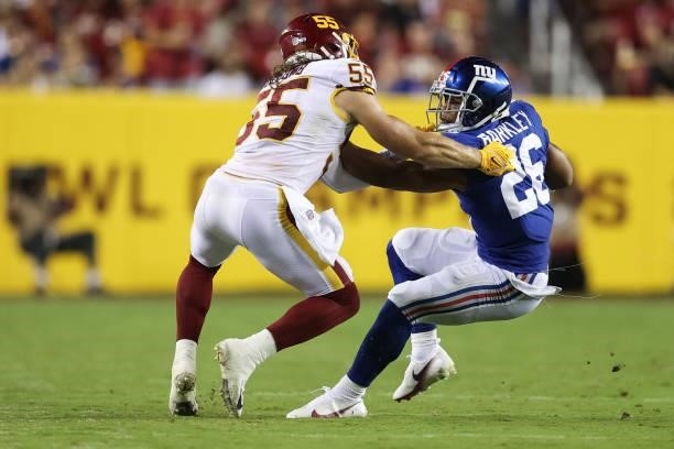 Saquon Barkley of the New York Giants pushes of Cole Holcomb of the Washington Football Team during the third quarter at FedExField on September 16,...