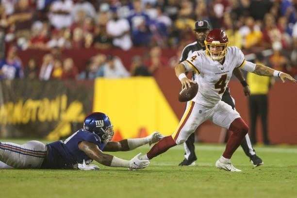 Taylor Heinicke of the Washington Football Team rushes from Leonard Williams of the New York Giants during the third quarter at FedExField on...