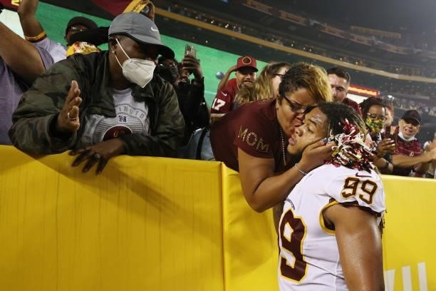 Chase Young of the Washington Football Team embraces a family member following a game against the New York Giants at FedExField on September 16, 2021...