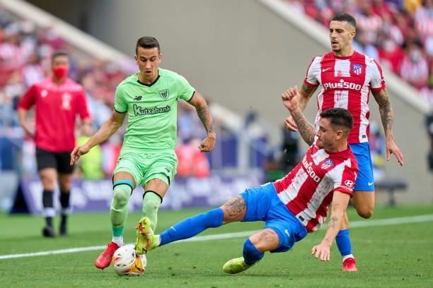 Jose Gimenez of Atletico de Madrid battle for the ball with Alex Berenguer of Athletic Club during the La Liga Santander match between Club Atletico...