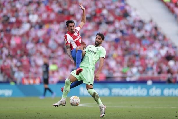 Raul Garcia of Athletic Club competes for the ball with Stefan Savic of Atletico de Madrid during the La Liga Santander match between Club Atletico...