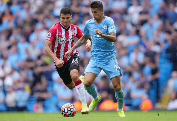 Joao Cancelo of Manchester City is challenged by Mohamed Elyounoussi of Southampton during the Premier League match between Manchester City and...