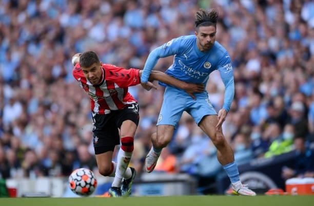 Jack Grealish of Manchester City battles for possession with Jan Bednarek of Southampton during the Premier League match between Manchester City and...
