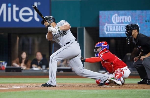 Jose Abreu of the Chicago White Sox hits a sacrifice fly to score a run against the Texas Rangers during the first inning at Globe Life Field on...