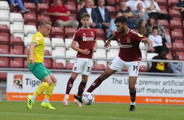 Kion Etete of Northampton Town looks to move with the ball past Louis Reed of Swindon Town during the Sky Bet League Two match between Northampton...