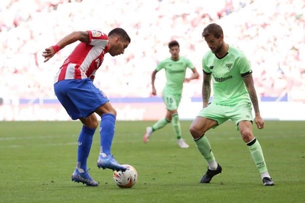 Luis Suarez of Atletico de Madrid competes for the ball with Inigo Martínez of Athletic Club during the La Liga Santander match between Club Atletico...