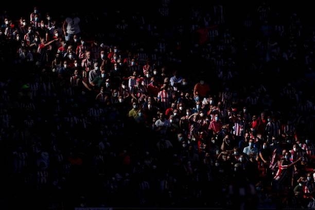 Supporters wearing masks attend the La Liga Santander match between Club Atletico de Madrid and Athletic Club at Estadio Wanda Metropolitano on...