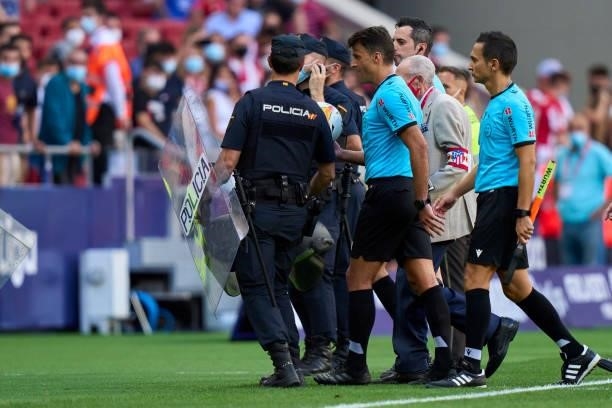 Referee Gil Manzano is protect y the police after the game during the La Liga Santander match between Club Atletico de Madrid and Athletic Club at...
