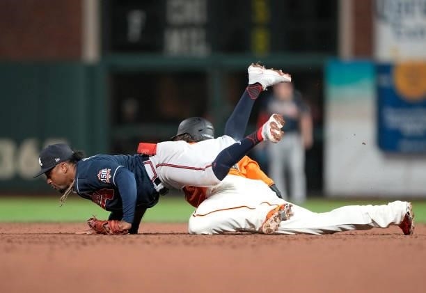 Brandon Crawford of the San Francisco Giants dives back into second base safe under Ozzie Albies of the Atlanta Braves in the bottom of the 11th...