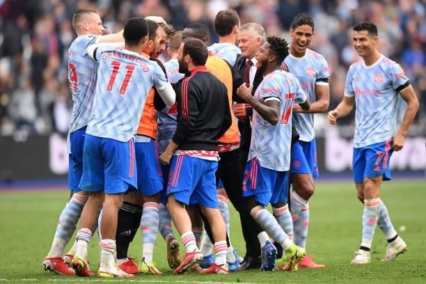 Ole Gunnar Solskjaer, Manager of Manchester United and Players of Manchester United embrace teammate David De Gea after saving the penalty taken by...