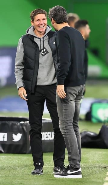 Team coach Mark van Bommel of Wolfsburg talks to team coach Oliver Glasner of Frankfurt before the Bundesliga match between VfL Wolfsburg and...