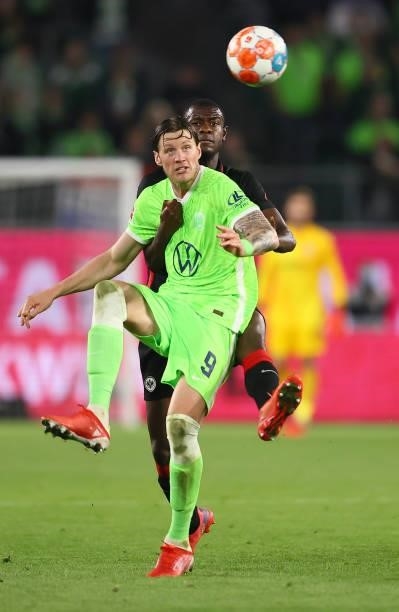 Wout Weghorst of Wolfsburg fights for the ball with Evan Ndicka of Frankfurt during the Bundesliga match between VfL Wolfsburg and Eintracht...