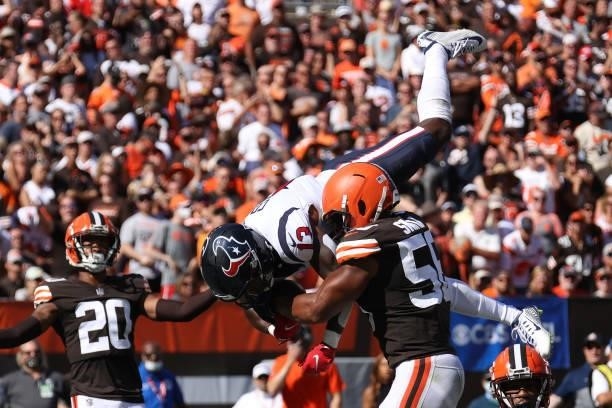 Wide receiver Brandin Cooks of the Houston Texans flips as he makes a catch over outside linebacker Malcolm Smith of the Cleveland Browns to score a...