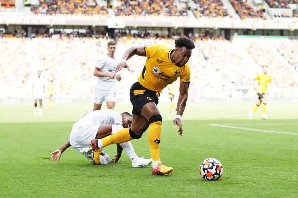 Adama Traore of Wolverhampton Wanderers is challenged by Rico Henry of Brentford during the Premier League match between Wolverhampton Wanderers and...