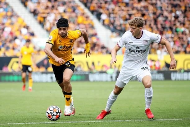 Raul Jimenez of Wolverhampton Wanderers runs with the ball under pressure from Mads Roerslev of Brentford during the Premier League match between...